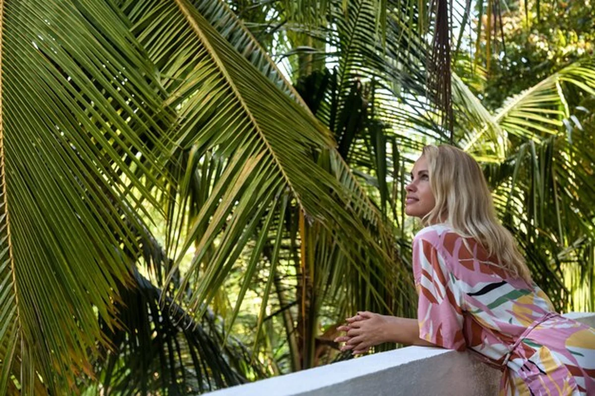 Młoda kobieta w szlafroku na hotelowym balkonie