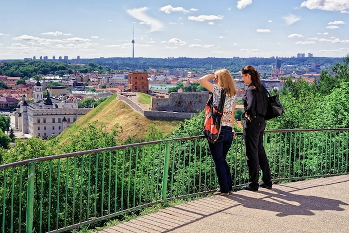 Kobiety oglądające Wieżę Giedymina na wzgórzu i Dolny Zamek w dół wzgórza w Wilnie na Litwie