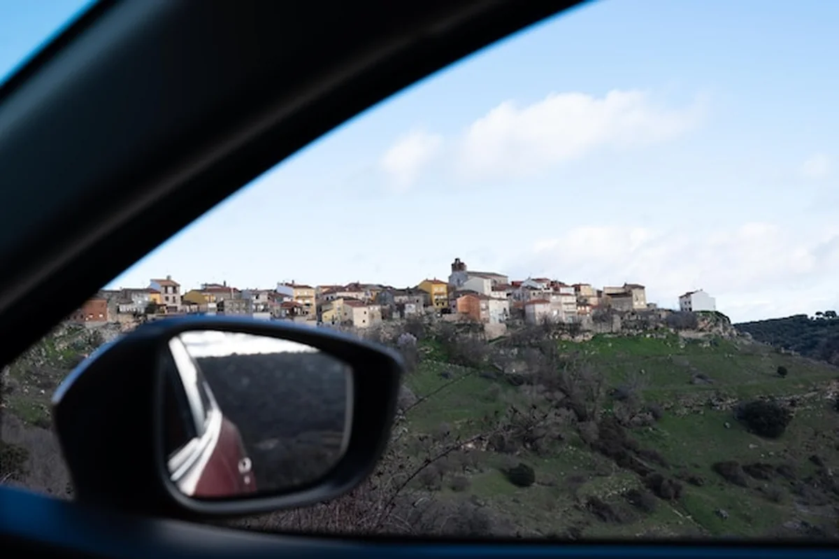 Widok z samochodu na hiszpańskie miasto na wzgórzu