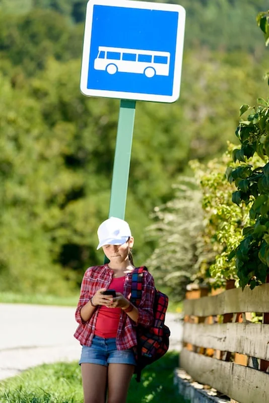 Uczennice w białym kapeluszu, czekają na autobus
