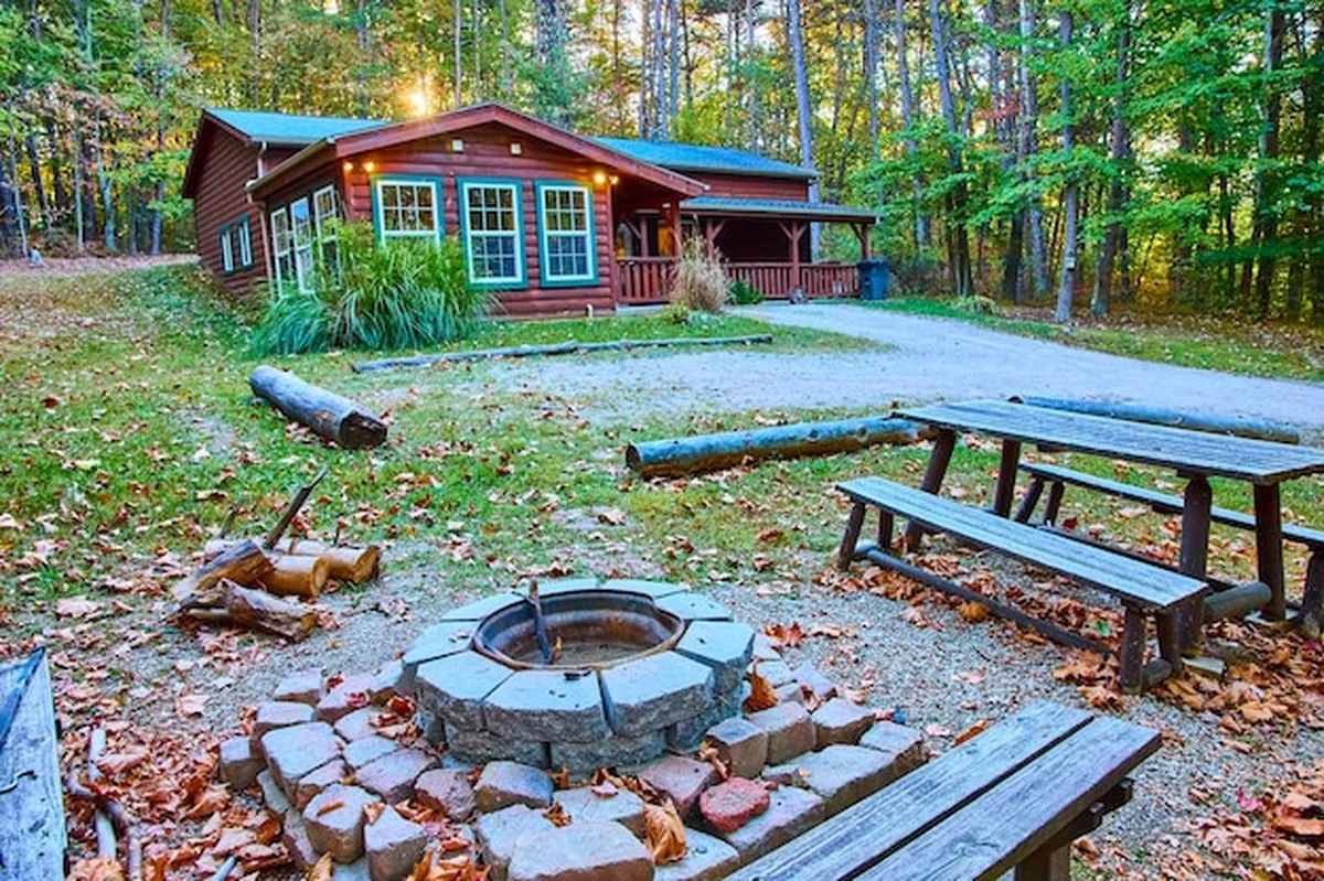 Rustyczna chatka z kominkiem w jesiennym lesie